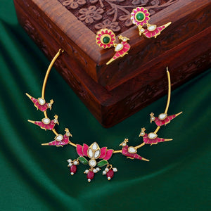 Temple-style ruby necklace with peacock and lotus motifs, pearl accents, and antique gold finish.