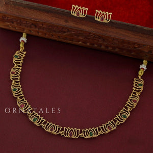 Rajnandini Lotus Garland Necklace Set featuring alternating lotus motifs with emerald and pink kundan stones, antique gold finish, and matching earrings.