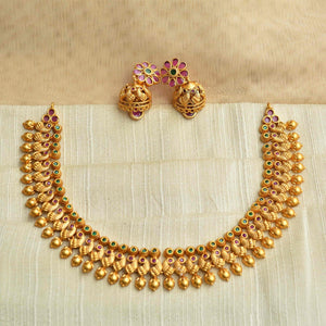 Traditional antique gold Kanakavalli necklace set handcrafted with round gold beads and mini kundan insets, paired with floral motif earrings.
