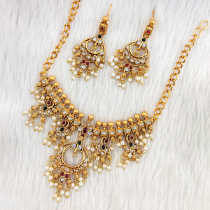 South Indian choker necklace in matte gold with circular red and white stone motif, pearl and gold bead fringes, intricate temple filigree, and matching earrings.