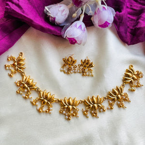 Suvarna Padmakshi Necklace Set with matte gold lotus motifs, dangling pearl details, and matching earrings in traditional temple-inspired design.