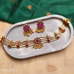 Traditional ruby kundan choker with crescent pendant, pearl drops, antique gold finish, and matching earrings.