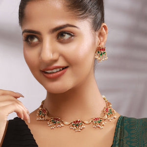 Mrinalika Lotus Cascade Necklace Set featuring ruby and emerald kundan lotus motifs, layered pearl hangings, and matching earrings.