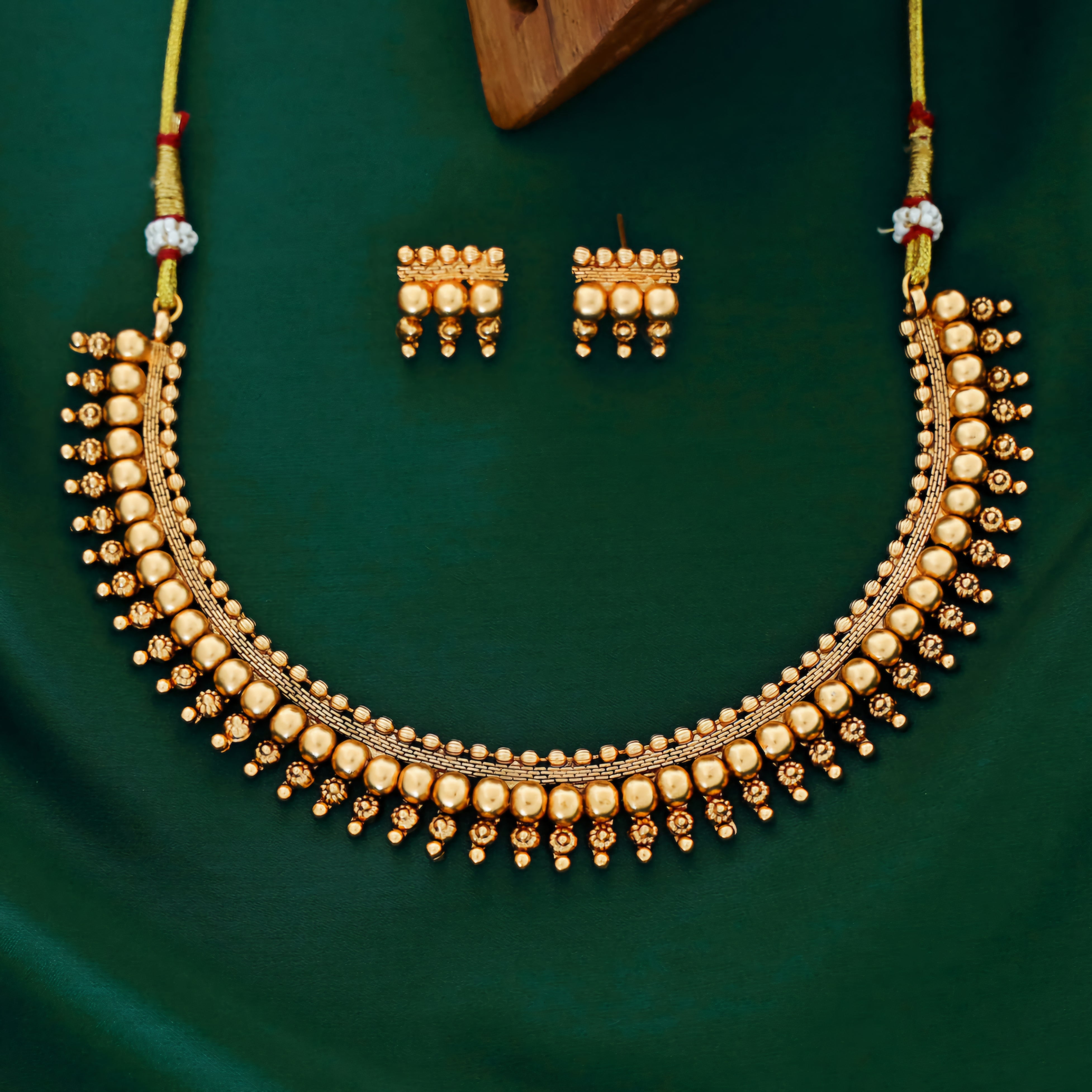Antique gold beaded choker necklace with triple-layer gold ball beads, temple-inspired detailing, and matching earrings.