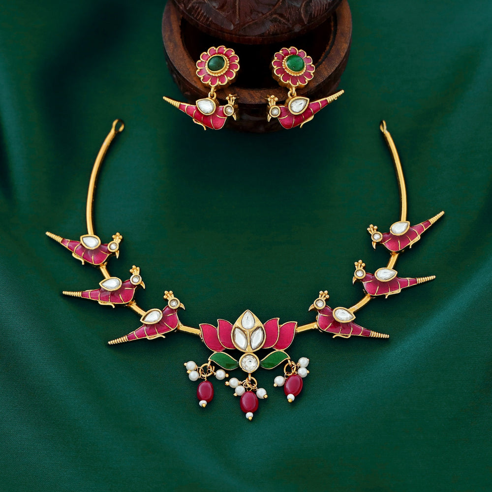 Temple-style ruby necklace with peacock and lotus motifs, pearl accents, and antique gold finish.