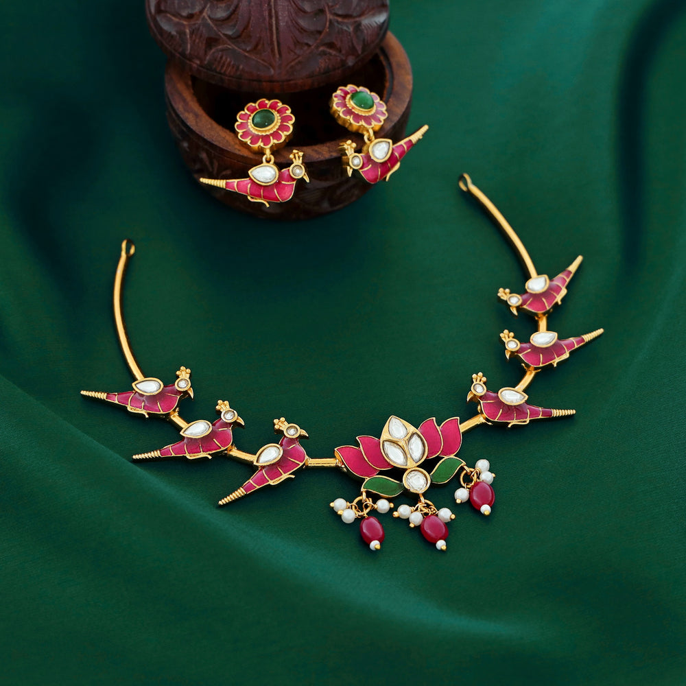 Temple-style ruby necklace with peacock and lotus motifs, pearl accents, and antique gold finish.