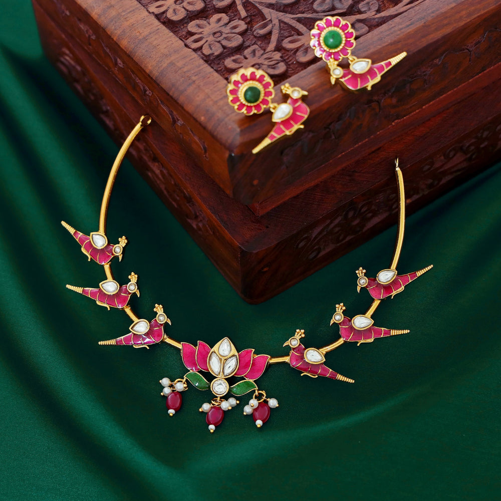 Temple-style ruby necklace with peacock and lotus motifs, pearl accents, and antique gold finish.