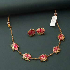 Padmavathi Blossom choker set with ruby enamel lotus motif, emerald green leaves, and gold link chain featuring matching stud earrings.