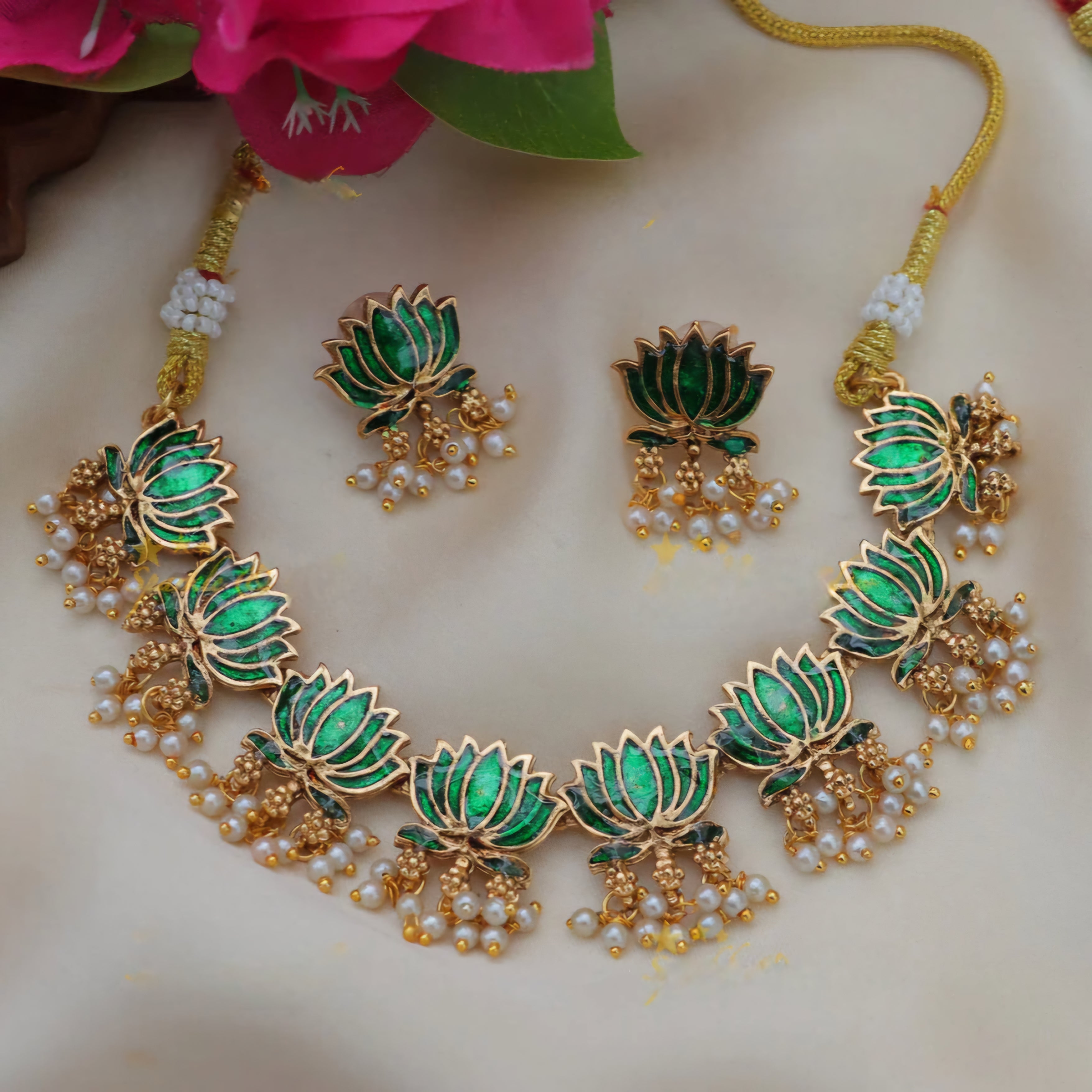 Kamalini Pearl Drop Choker Set with emerald green lotus motifs, golden detailing, hanging pearl clusters, and matching lotus drop earrings.