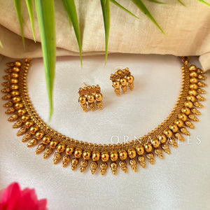 Antique gold beaded choker necklace with triple-layer gold ball beads, temple-inspired detailing, and matching earrings.