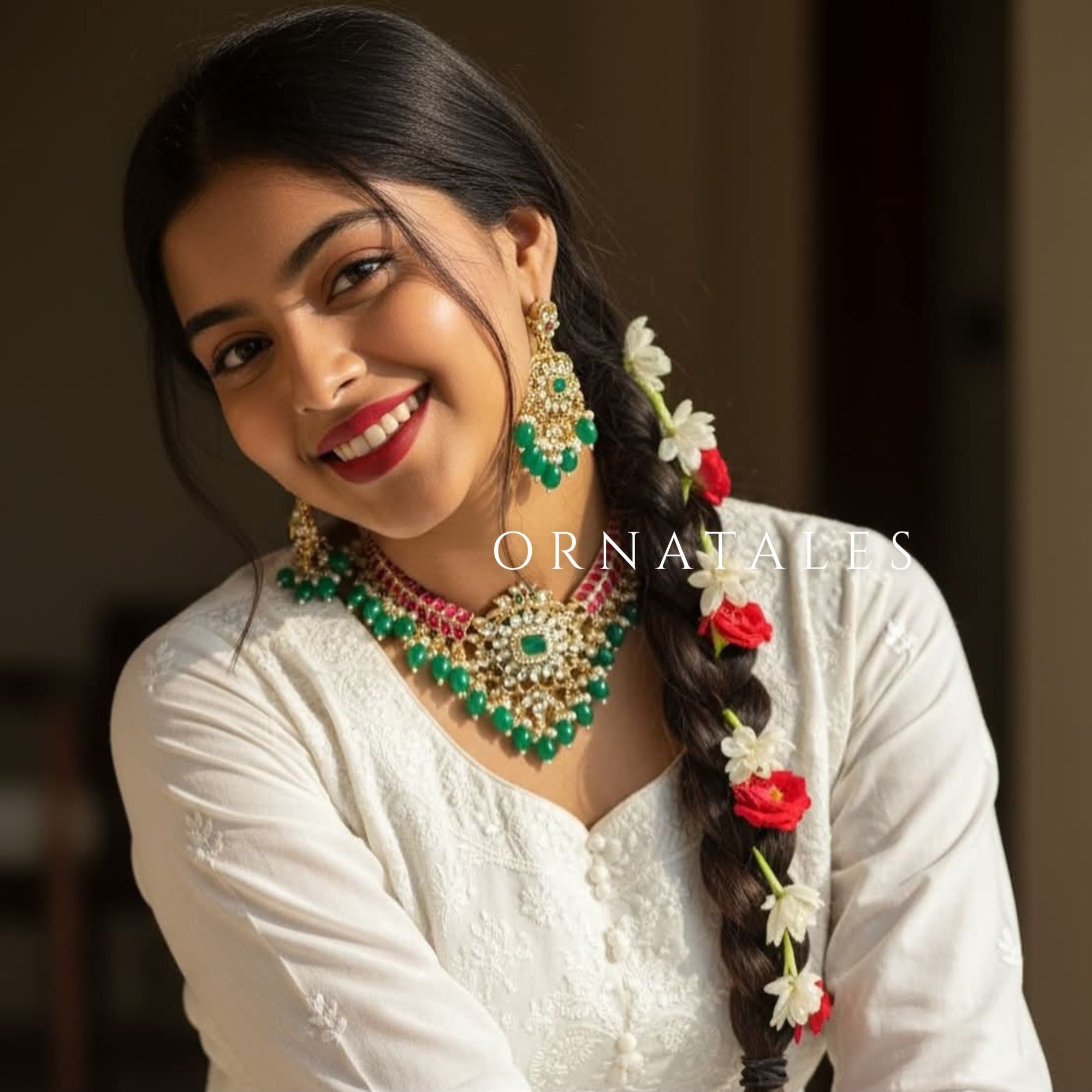 Temple-inspired Emerald Kumuda necklace set featuring green teardrop stones, red kundans, and a center emerald-cut stone.