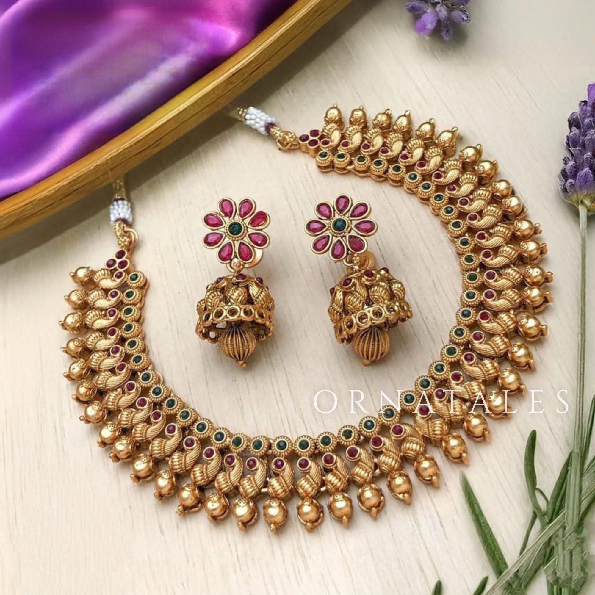 Traditional antique gold Kanakavalli necklace set handcrafted with round gold beads and mini kundan insets, paired with floral motif earrings.