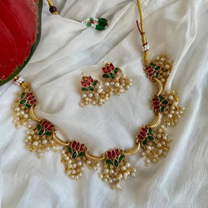 Anuragini Pearl Lotus Choker Set with ruby and emerald kundan lotus motifs, pearl fringe detailing, and matching earrings.