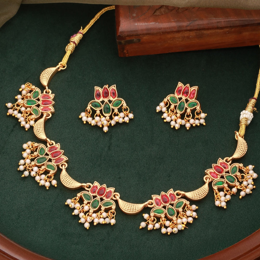 Mrinalika Lotus Cascade Necklace Set featuring ruby and emerald kundan lotus motifs, layered pearl hangings, and matching earrings.