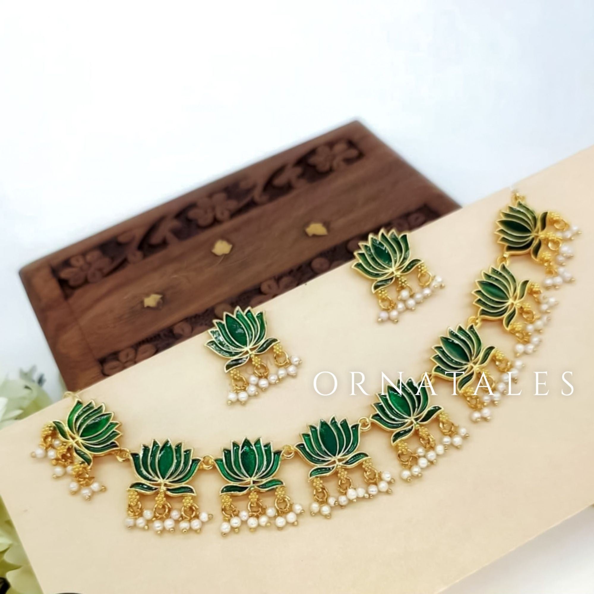 Kamalini Pearl Drop Choker Set with emerald green lotus motifs, golden detailing, hanging pearl clusters, and matching lotus drop earrings.