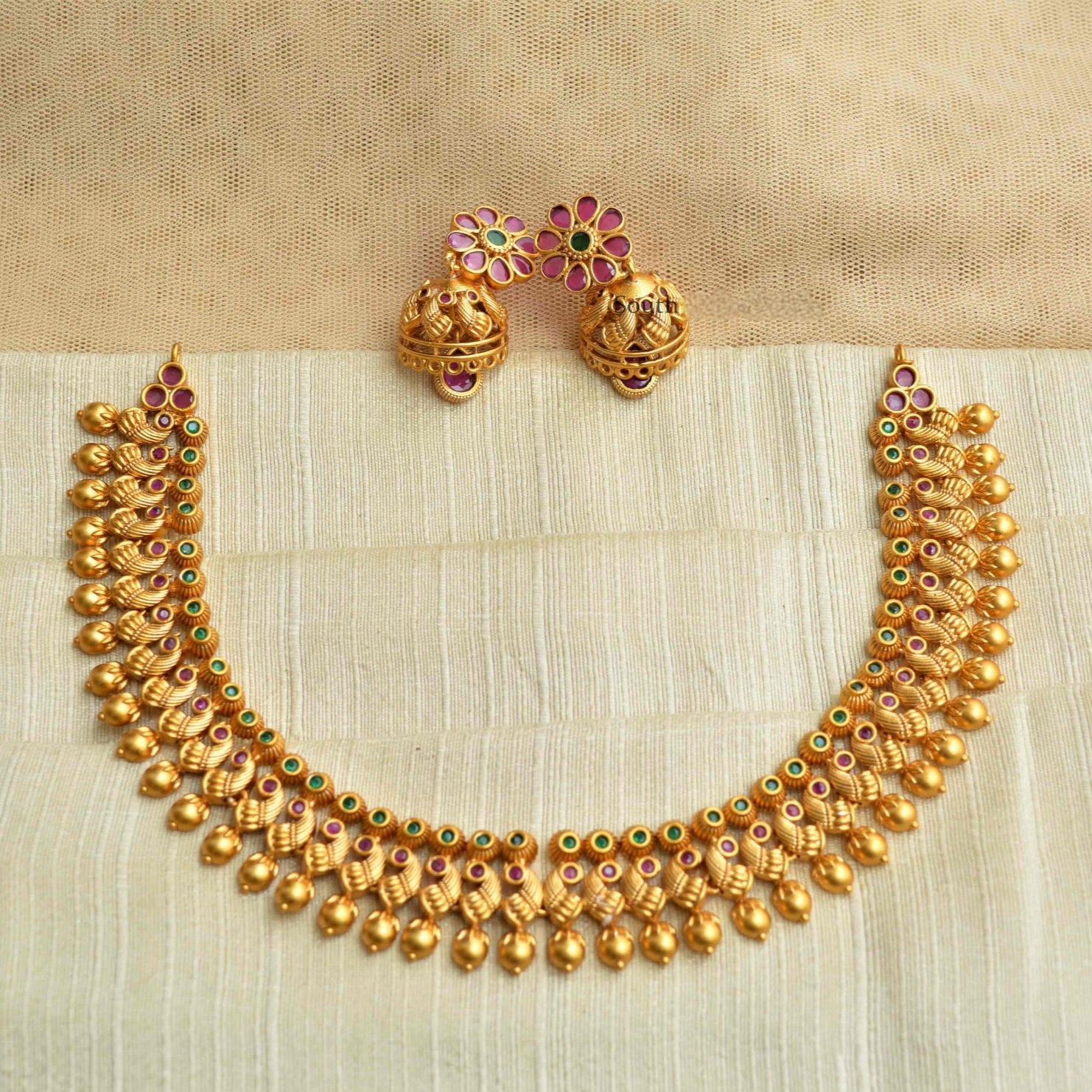 Traditional antique gold Kanakavalli necklace set handcrafted with round gold beads and mini kundan insets, paired with floral motif earrings.