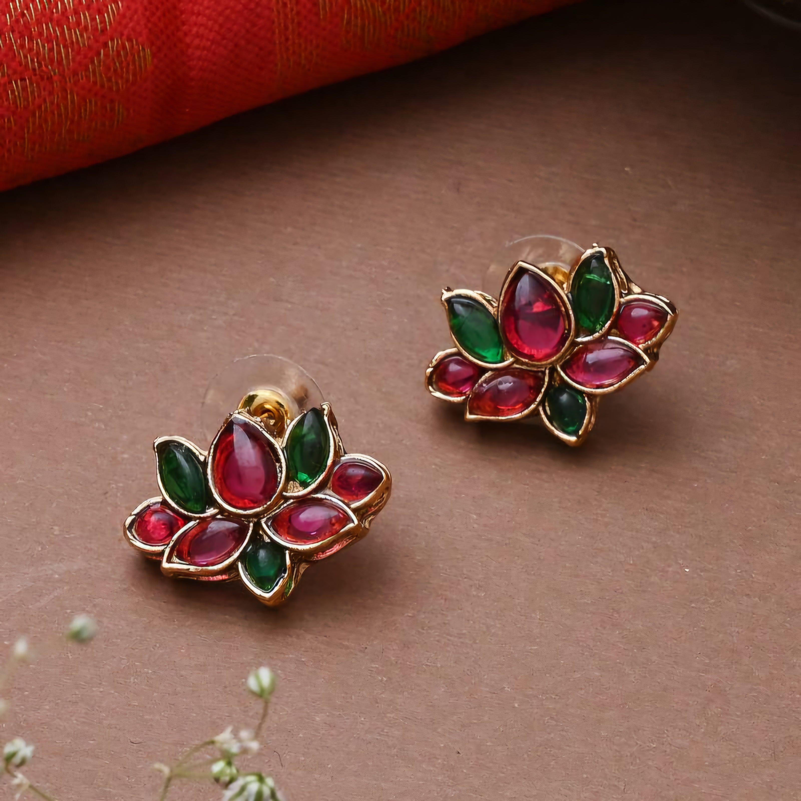 Matte gold South Indian choker with floral vine motifs, red and green enamel stones, flexible base, and matching floral stud earrings.