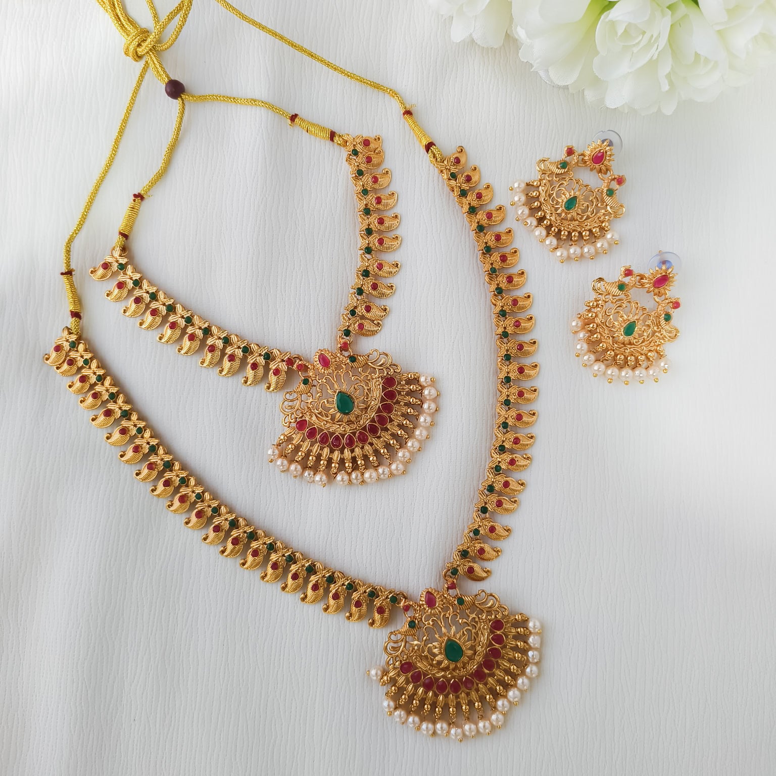 Mayurika dual-layer temple combo set featuring peacock motifs, mixed stones, and pearl drop edging in a matte gold finish.