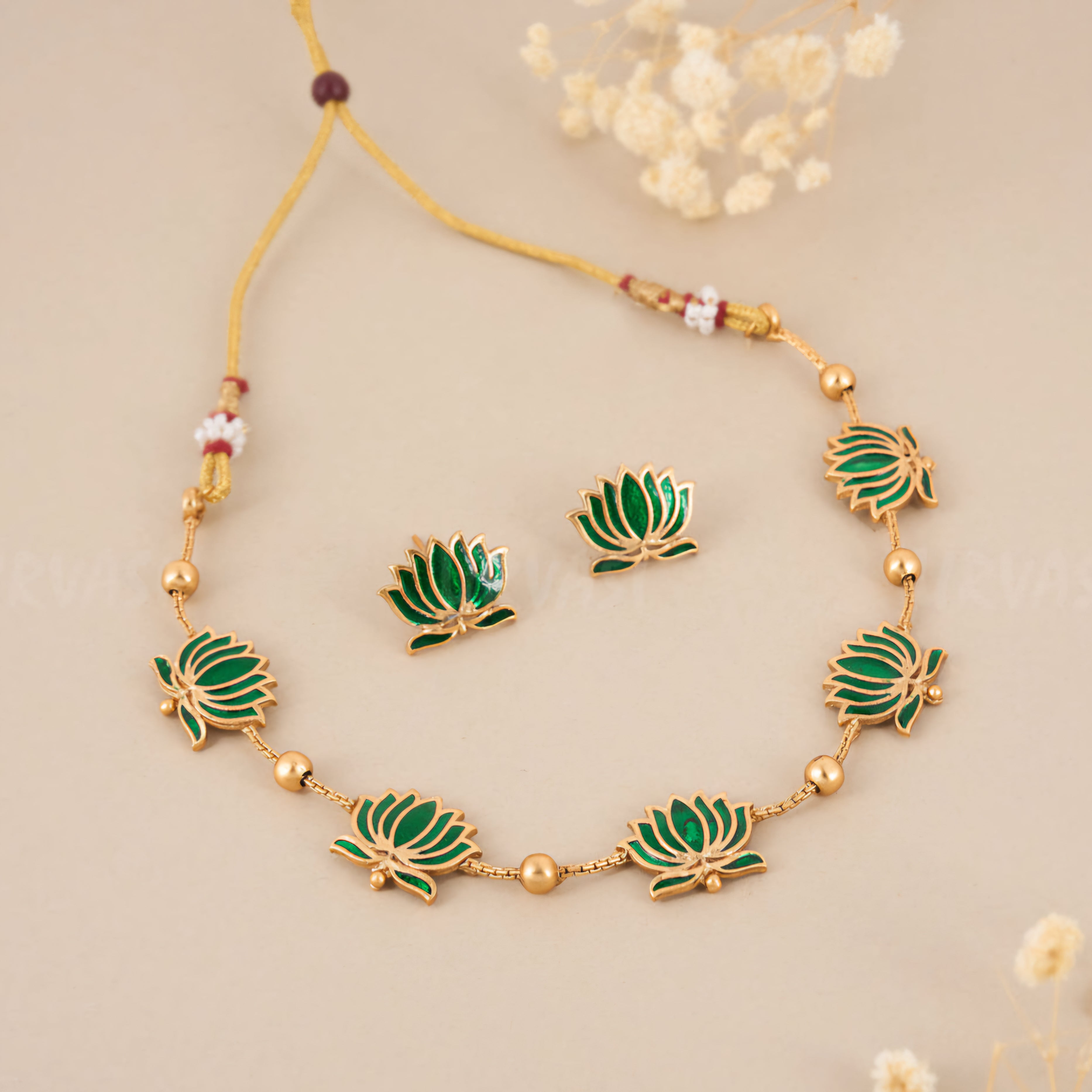 Padmavathi Blossom choker set with emerald green enamel lotus motif, gold link chain, and matching stud earrings in a traditional temple design.