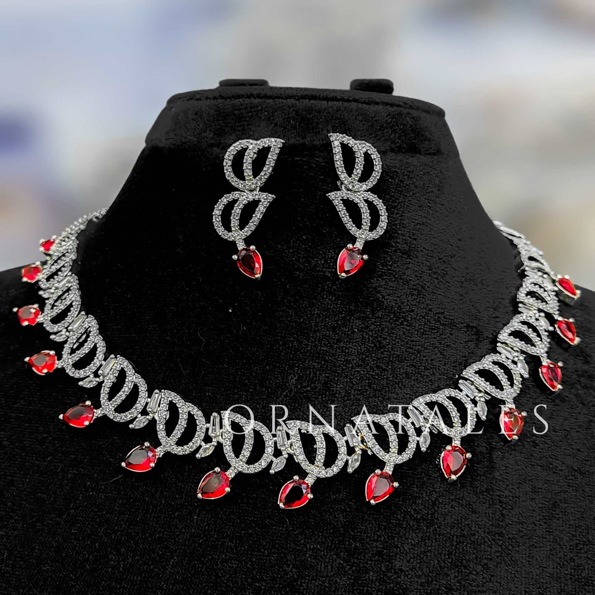 Ruby Red Diamond Cut Necklace Set with wave-like looping structure and droplet stones – matching earrings – Ornatales