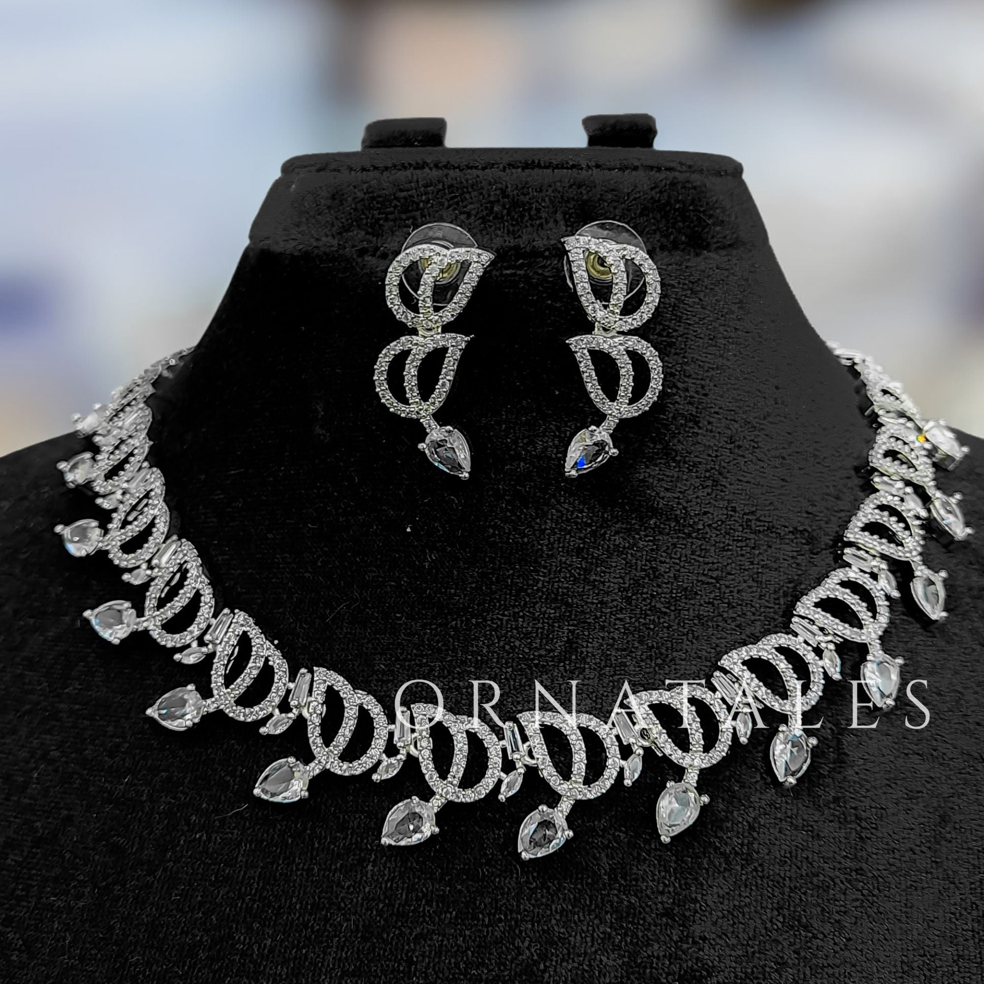 Crystal White Diamond Cut Necklace Set with wave-like looping structure and droplet stones – matching earrings – Ornatales