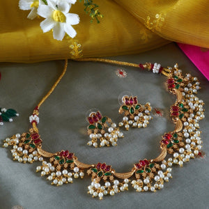 Anuragini Pearl Lotus Choker Set with ruby and emerald kundan lotus motifs, pearl fringe detailing, and matching earrings.