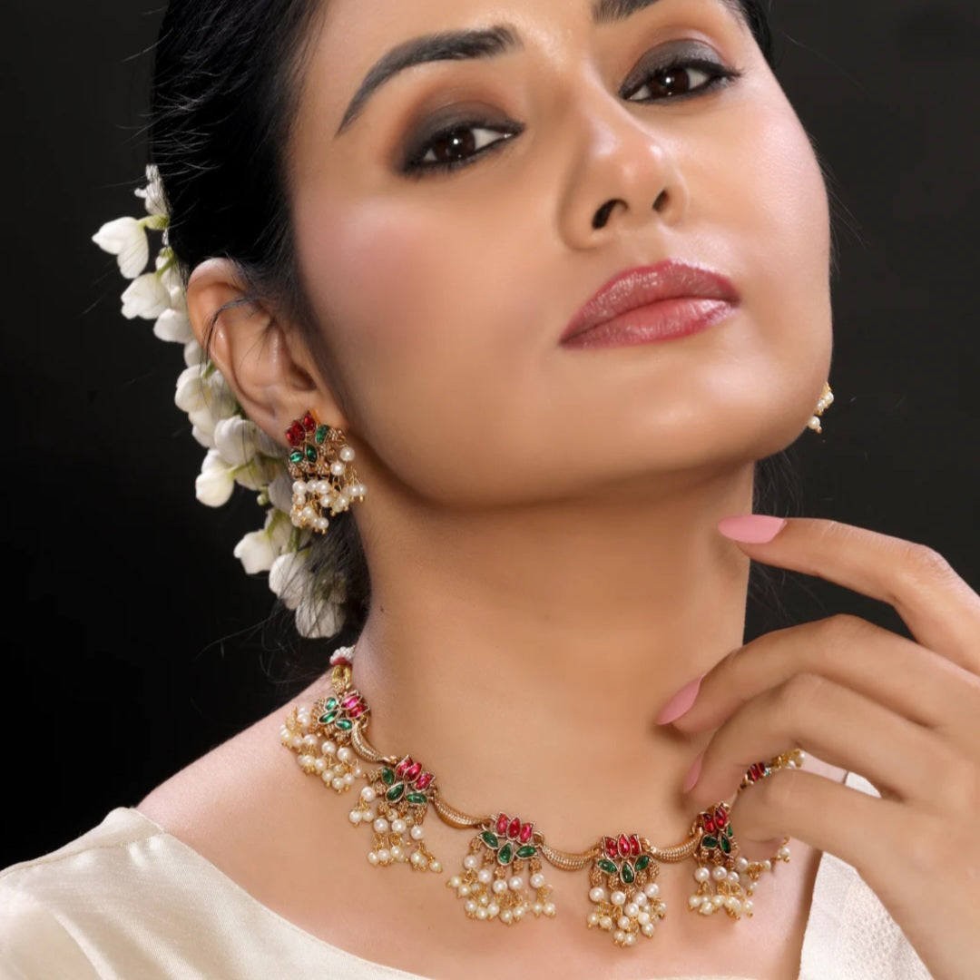 Anuragini Pearl Lotus Choker Set with ruby and emerald kundan lotus motifs, pearl fringe detailing, and matching earrings.