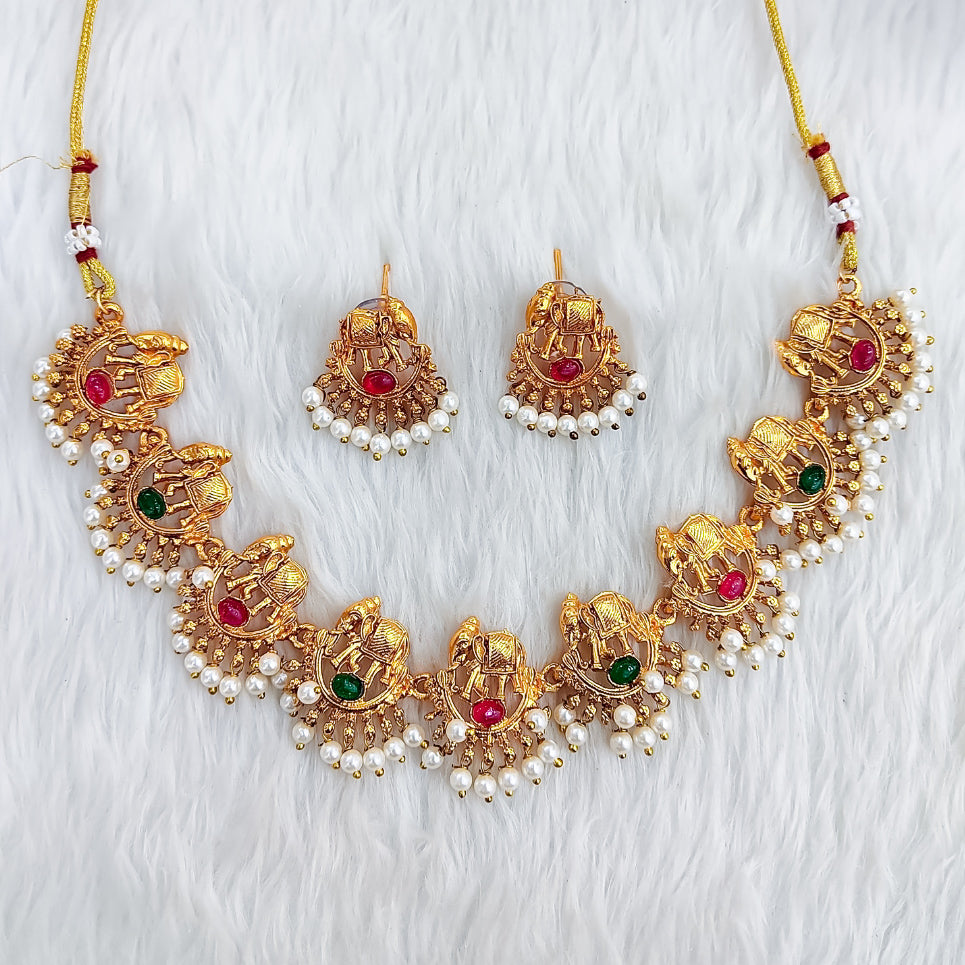 Matte gold South Indian choker with temple-style elephant (Hatimala) motifs, red and green stones, pearl fringe, and matching jhumka earrings.