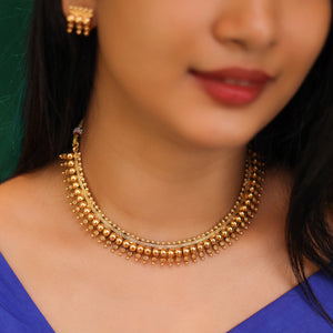 Antique gold beaded choker necklace with triple-layer gold ball beads, temple-inspired detailing, and matching earrings.